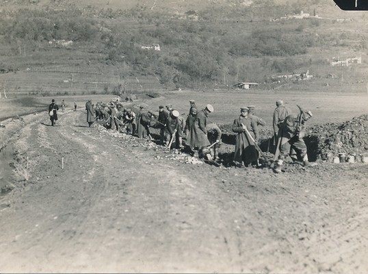 Ruski vojni ujetniki popravljajo cesto v Lokah ob nadzoru avstrijskega stražarja (na levi v črnem oblačilu).