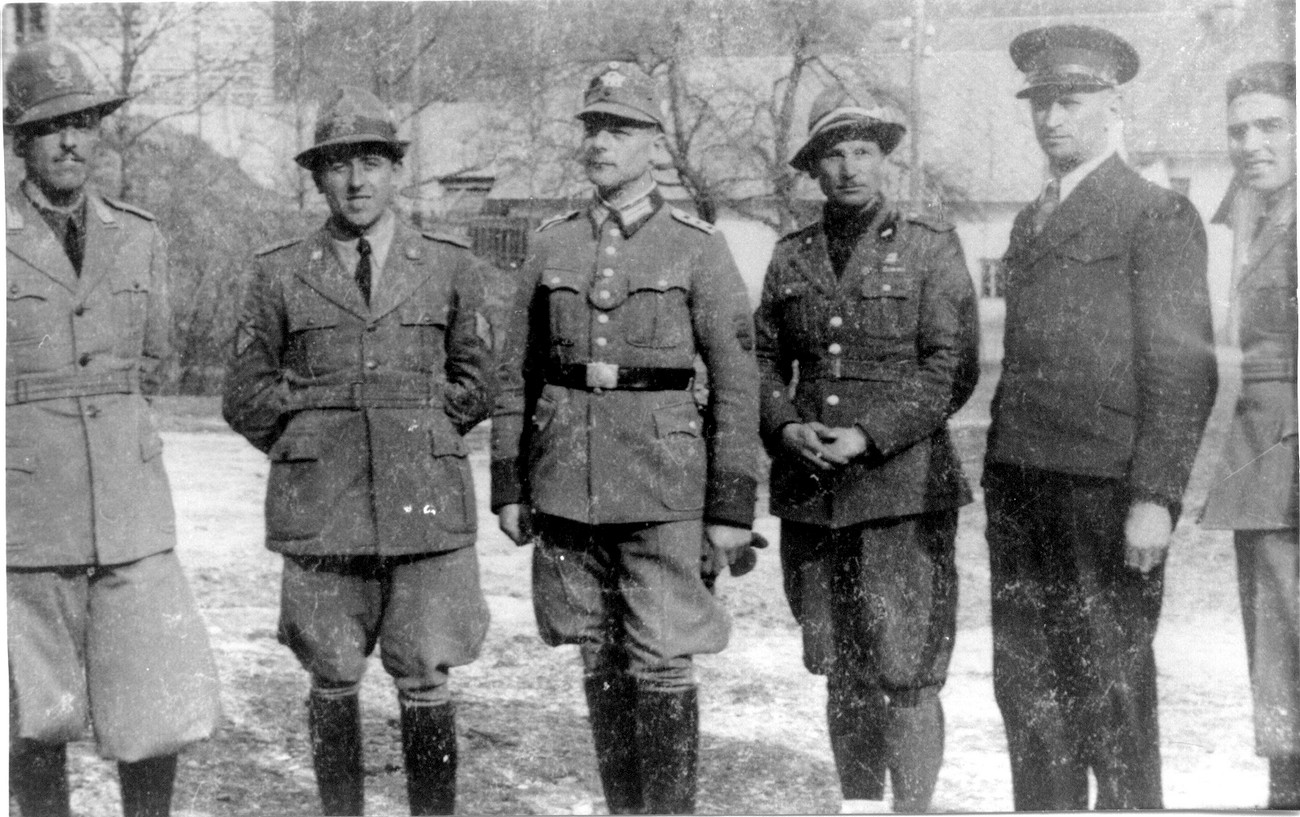 Na fotografiji so (z leve) italijanski finančni stražnik, brigadir mejne posadke finančnih straž v Podlanišču, poveljnik nemške mejne orožniške postaje iz Sovodnja Perfler, pripadnik obmejne fašistične milice, jugoslovanski carinik Lipicer in še en fašistični miličnik. Fotografija je bila osneta na mejnem prehodu v Podlanišču okrog 11. aprila 1941. Pavšič, Ob stari meji (Založba Bogataj), 75. Original hrani Mestni muzej Idrija.
