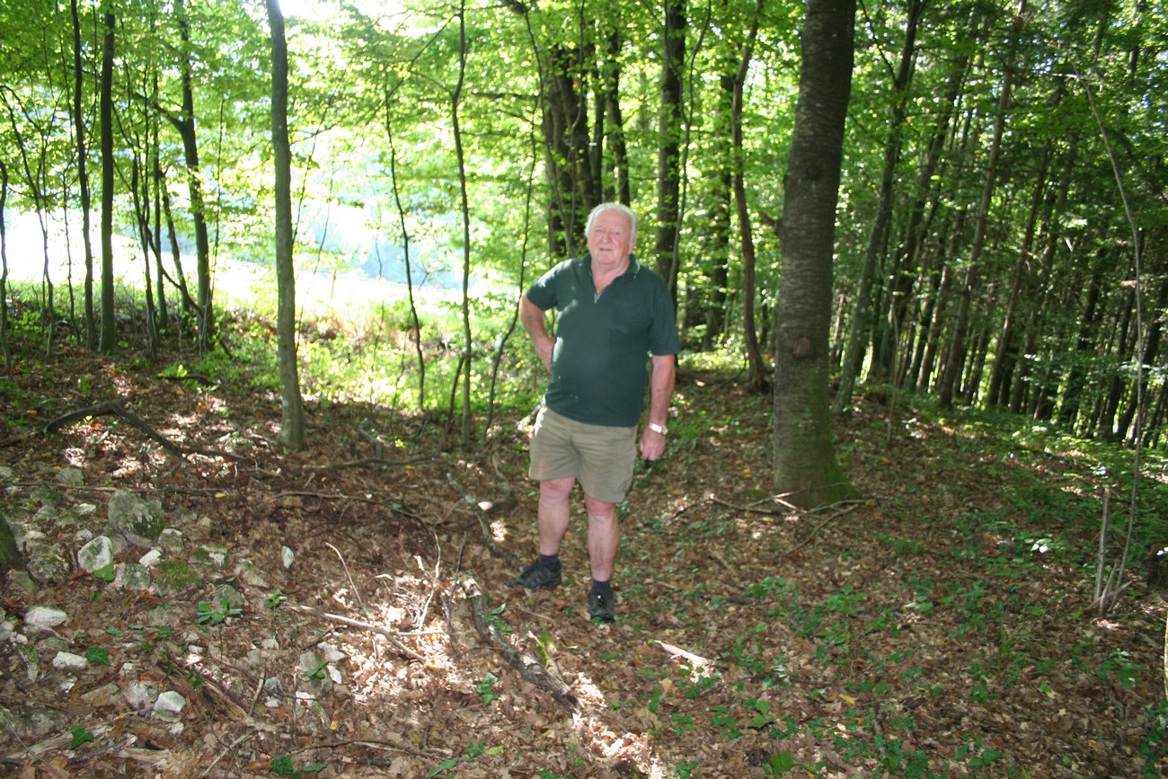 Anton Palčič in the location of an Italian bunker in Zaboršt near the village of Kočarija. The remains of barbed wire can be seen in front of him. Because of the barricade of the border towards the NDH, his father had to deforest an area 50m wide and between 500 and 600m long. Author: Božidar Flajšman.